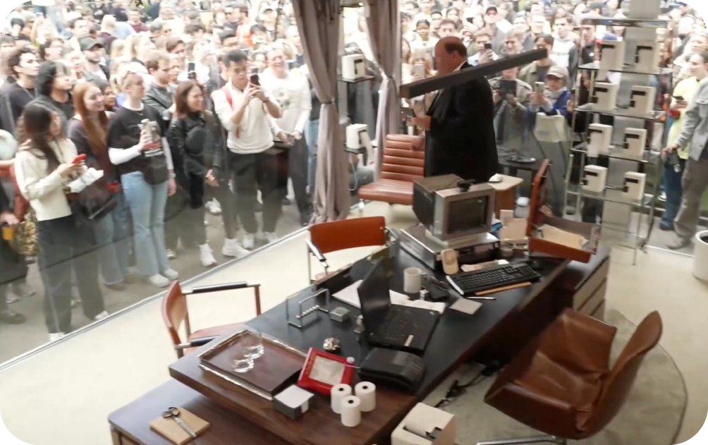 A large crowd gathering on an NYC street to watch Brian Baumgartner work inside a transparent glass office for the Ramp marketing stunt.